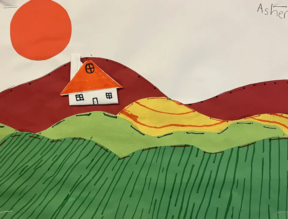 A paper collage landscape with a red-roofed house on green striped fields beneath an orange sun.